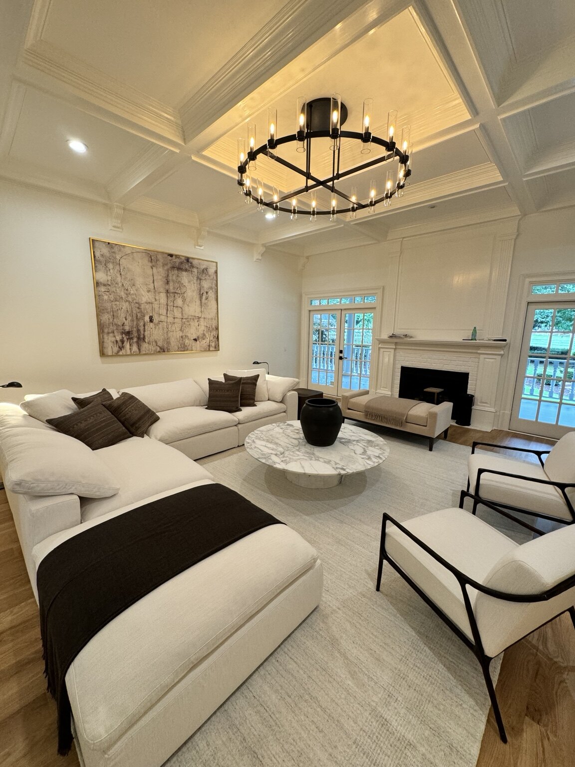 Living room after renovation with pale finishes and coffered ceiling