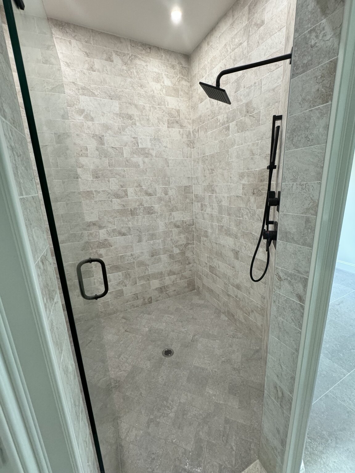 Bathroom after renovation with walk-in stone shower and black fittings